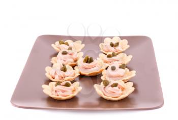 Fish cream and  capers in pastries on brown plate.