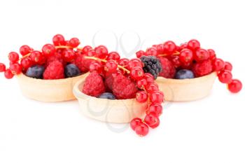 Fresh ripe berries in tartlets isolated on white background.
