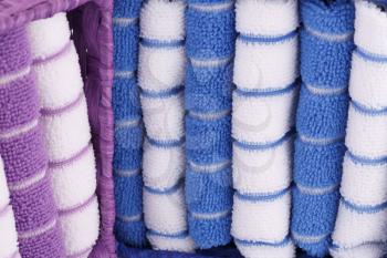 Pink, blue and white folded towels in boxes closeup picture.