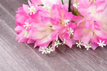 Colorful fabric flowers on wooden background, closeup picture.