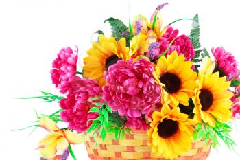 Colorful fabric flowers in wicker basket isolated on white background.