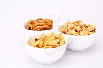 Different salted crackers in bowl isolated on white background.