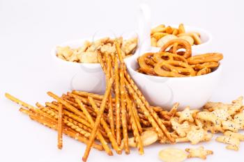 Different salted crackers in bowl isolated on white background.