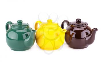 Green, yellow and brown teapots isolated on a white background.
