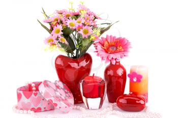 Flowers in vases, red heart glass, necklace, gift box and candles isolated on white background.