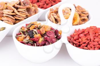 Dried fruits, berries and seeds in bowls closeup picture.
