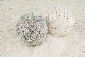 Christmas decoration with balls on the artificial snow and golden net background.