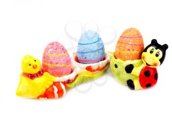 Easter decoration with colorful eggs in ceramic settings isolated on white background.