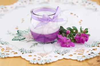 Beautiful candle and pink flowers on cloth background.