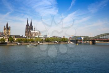 Roman Catholic Gothic Cathedral, Great St. Martin church, main train station and  Hohenzollern Bridge in Germany, view from the other side of Rhine river.