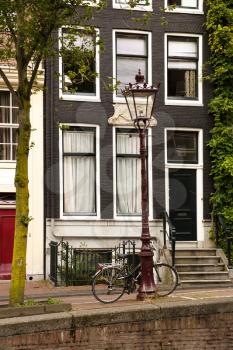 Traditional old building with lamp and bicycle in Amsterdam, Neterlands.