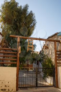 Old building with gate and hanging chairs in Limassol, Cyprus.