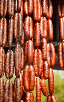 Homemade delicious sausages hanging in line at the market.