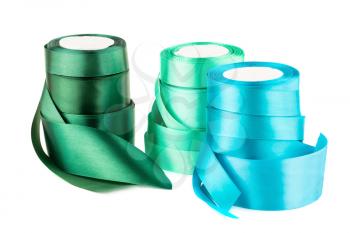Green and blue silk ribbon reels isolated on white background.
