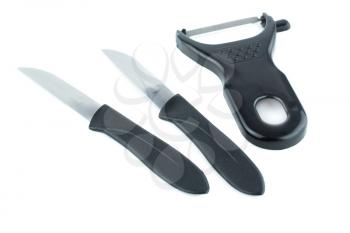 Knives and vegetable peeler with black plastic holders isolated on white background.