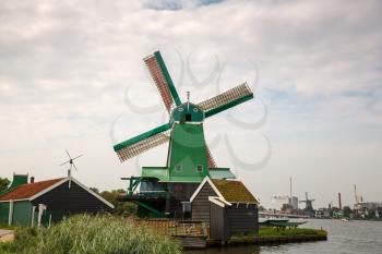 Traditional, authentic dutch windmills at the river Zaam in Zaanse Schans village.