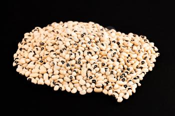 Black eyed beans isolated on a black background.