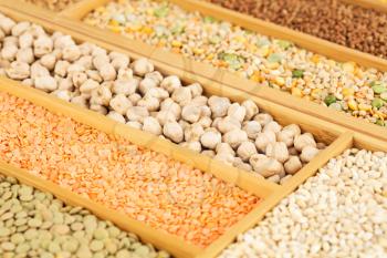 The collection of different groats, lentils, chickpeas, peas, wheat and buckwheat in the wooden box.