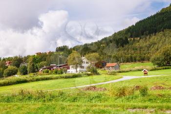 Rural place with village houses and mountains in Norway.