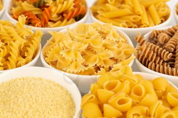 Various kind of Italian pasta in the white ceramic bowls.