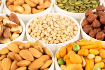 The various kind of nuts and seeds in the white ceramic bowls.