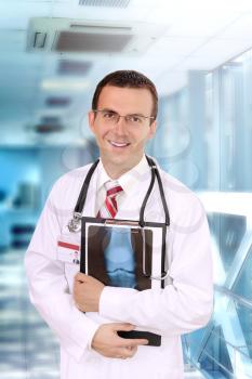 Friendly medical doctor stand with a x-ray image and medical pad in a Hospital emergency section.