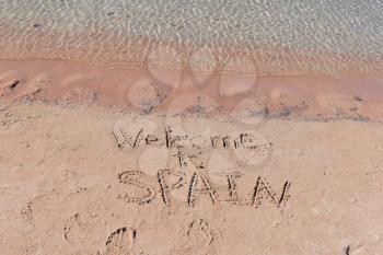 Inscription Welcome to Spain on a sand n a  beach.