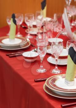 Table appointments on red tablecloth.Accent focus on front.