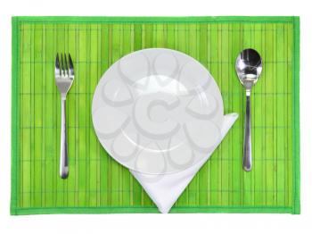 Table serving-knife,plate,fork and silk napkin  on  green colour background.