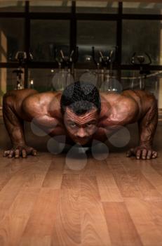 male bodybuilder doing push ups at the floor