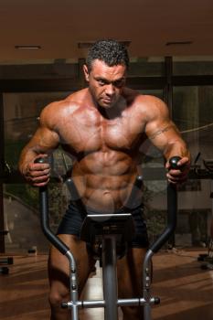 male bodybuilder using the elliptical machine