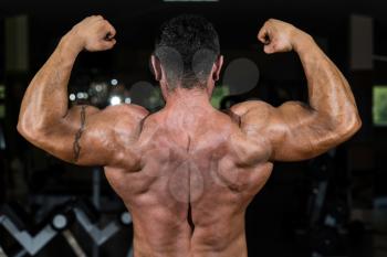 muscular bodybuilder showing his back double biceps