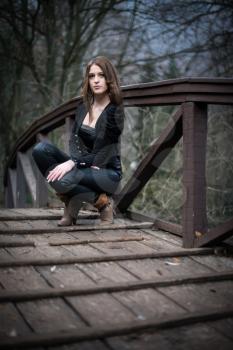 young woman crouch at bridge