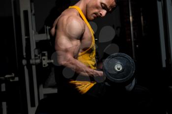 young man doing heavy weight exercise for biceps