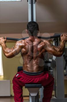 shirtless bodybuilder doing heavy weight exercise for back