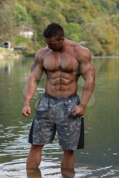 Attractive Man Standing In River And Enjoys The Nature