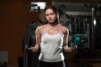 Young Woman Doing Heavy Weight Exercise For Biceps With Dumbbells