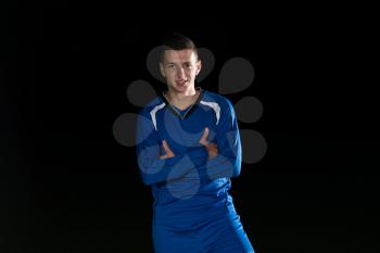 Portrait Of A Soccer Player And Ball On Football Stadium Field Isolated On Black Background