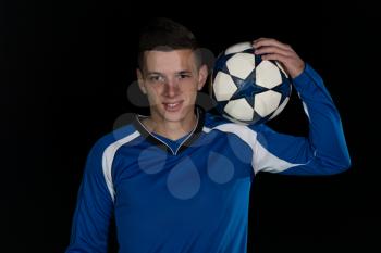 Soccer Player And Ball On Football Stadium Field Isolated On Black Background