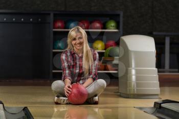 Cheerful Young Women Holding Bowling Ball