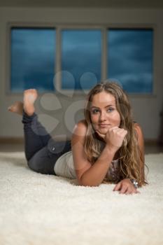 Beautiful Young Woman Relaxing On Carpet