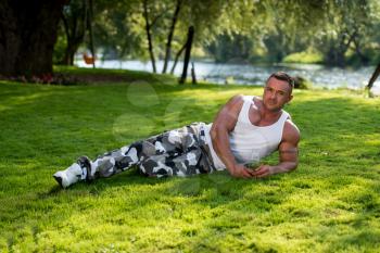 Bodybuilder Resting And Holding Water Bottle