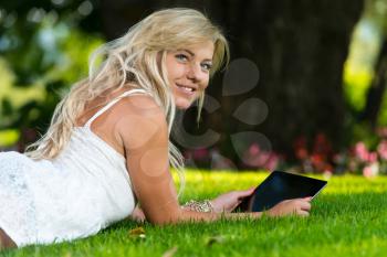 Young Woman using a digital tablet in the park