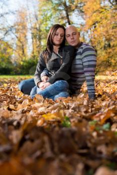 Couple Sitting Together In The Woods During Autumn