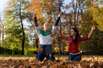 Couple Throwing Leaves In The Air