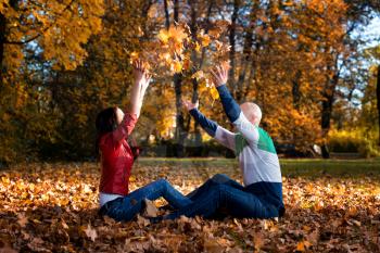 Loving Couple Toss The Leaves In Autumn Park