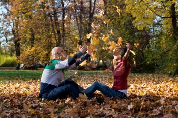 Young Couple Throwing Fall Leaves