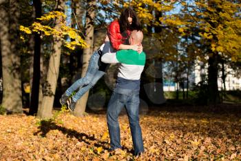 Man Carrying Woman Ride Through Autumn Woods