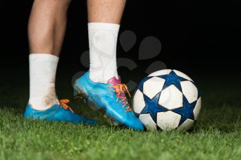 Legs Of Soccer Player With Ball On Dark Background