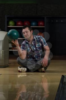 Cheerful Young Man Holding Bowling Ball